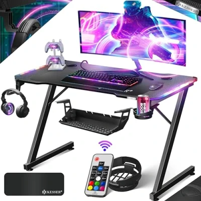 Image de KESSER® Table de Jeu LED 120 cm x 60 Bureau Gamer en Forme Z Crochet pour Casque et revêtement Carbone d&#039;ordinateur Ergonomique Stable avec Porte gobelet Noir